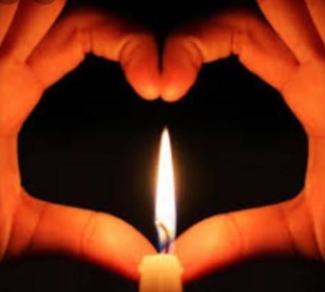 Hands forming a heart around a flame